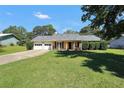 Charming single-story home with a welcoming front porch, attached garage, and a well-manicured lawn at 107 Gwenellen Dr, Locust Grove, GA 30248