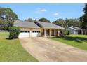 Inviting home featuring an attached garage, covered front porch, and a spacious driveway at 107 Gwenellen Dr, Locust Grove, GA 30248