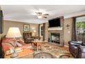 Cozy living room with a brick fireplace, plush leather furniture, and a ceiling fan at 173 Price Rd, Brooks, GA 30205