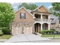 Charming two-story brick home with a stone accent, inviting front porch, manicured landscaping, and a two-car garage at 2652 Brickell Sq, Atlanta, GA 30341