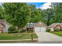 Exterior view of inviting home featuring a well-maintained lawn and a two-car garage at 1909 Riverlanding Cir, Lawrenceville, GA 30046