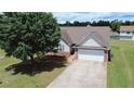 Charming one-story home featuring a well-manicured lawn and a two-car garage at 1332 Kent Mnr, Stockbridge, GA 30281