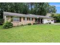 Single-story home with brick and siding, lush lawn, and attached two-car garage at 1239 Sharonton Dr, Stone Mountain, GA 30083