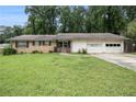 Charming single-story home with brick facade, lush lawn, and attached two-car garage at 1239 Sharonton Dr, Stone Mountain, GA 30083