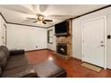 Cozy living room features a brick fireplace, dark wood floors, and a comfortable leather sofa at 1239 Sharonton Dr, Stone Mountain, GA 30083