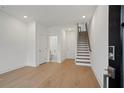 Hardwood floors with staircase and bathroom access in this modern living room at 651 Soul Aly # 135, Alpharetta, GA 30009