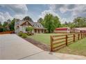 Beautiful two-story home with a sprawling green lawn, fencing, and a long driveway at 1142 Wiley Bridge Rd, Woodstock, GA 30188
