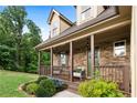 Charming stone home with a cozy covered porch featuring seating and manicured landscaping at 42 Treemont Se Dr, Cartersville, GA 30121