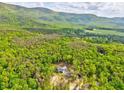 Expansive view showcasing a home surrounded by a vast, flourishing forest and distant hills at 555 E Valley Ne Rd, Rydal, GA 30171