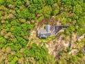 Birds-eye view of a secluded home, accessible via a private driveway amidst a dense forest at 555 E Valley Ne Rd, Rydal, GA 30171