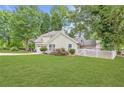 Beautifully landscaped front yard with lush green grass, flowering shrubs, and a white picket fence at 141 S Fairfield Dr, Peachtree City, GA 30269