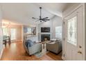 Cozy living room with vaulted ceilings, a fireplace, hardwood floors, and an open concept design at 141 S Fairfield Dr, Peachtree City, GA 30269