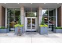 Elegant building entrance with glass doors, brick accents, and stylish planters for a welcoming arrival at 855 Peachtree Ne St # 2713, Atlanta, GA 30308