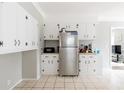 Functional kitchen featuring white cabinets, stainless steel refrigerator, and tiled floors at 1624 Beecher Sw St, Atlanta, GA 30310