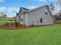 Side view of a gray home with a well-manicured lawn and mulch landscaping at 5291 Tuscany Dr, Douglasville, GA 30135