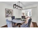Elegant dining room with a modern chandelier, plush velvet chairs, and an open view into the living area at 1172 Rockmart Nw Cir, Kennesaw, GA 30144