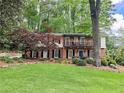 Two-story brick home with large front lawn, mature trees, and manicured landscaping on a sunny day at 2151 Desmond Dr, Decatur, GA 30033