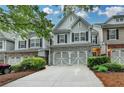 Charming townhouse with a brick-and-siding exterior, two-car garage and manicured landscaping at 2895 Cross Creek Dr, Cumming, GA 30040
