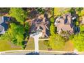 Aerial view showcasing a well-manicured home with mature trees, green lawns, and a concrete driveway at 5685 Commons Ln, Alpharetta, GA 30005