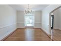 Formal dining room featuring hardwood floors, large windows, crown molding, and modern chandelier at 5685 Commons Ln, Alpharetta, GA 30005