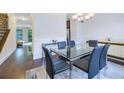 Stylish dining room with glass table, staircase, and hardwood floors at 7850 Willoughby Ct, Alpharetta, GA 30005