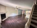 Open-concept living space with hardwood floors, a fireplace, and a partial view of the kitchen at 142 Davis Mill Ct, Lawrenceville, GA 30044