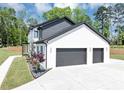 Side view of a pristine white home featuring an attached two-car garage and well-manicured landscaping at 2577 Kilgore Rd, Buford, GA 30519
