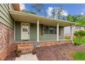 Inviting front porch of home featuring brick accents and a cozy sitting area at 3240 Corktree Trl, Stonecrest, GA 30038