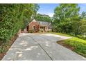 Long driveway leading to a brick home with lush greenery, offering privacy and ample parking space at 1590 Johnson Ne Rd, Atlanta, GA 30306