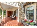 Covered front porch featuring brick flooring, stone accents, and comfortable seating, creating a welcoming entrance at 1590 Johnson Ne Rd, Atlanta, GA 30306