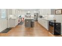 Spacious kitchen with white cabinets, stainless steel appliances, a center island, and hardwood flooring at 1590 Johnson Ne Rd, Atlanta, GA 30306