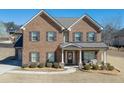 Beautiful two-story brick home showcasing a welcoming front porch with stone accents at 2225 Independence Ln, Buford, GA 30519