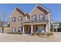 Beautiful two-story brick home featuring a cozy front porch and a well-manicured lawn at 2225 Independence Ln, Buford, GA 30519