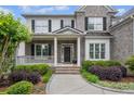 Charming home entrance with a covered porch, brick walkway, and lush landscaping at 2740 Cezanne Ln, Cumming, GA 30041