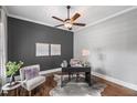 Stylish home office featuring a dark accent wall, hardwood floors, and a comfortable chair at 2740 Cezanne Ln, Cumming, GA 30041