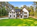 Beautiful two-story white brick home with black trim, windows and doors, and well-manicured front yard at 400 Auburn Rd, Auburn, GA 30011