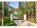 Secluded home behind black iron gate, nestled among trees, with expansive grassy yard at 400 Auburn Rd, Auburn, GA 30011