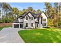 Beautiful white brick two-story home with black trim, two car garage and green lawn at 400 Auburn Rd, Auburn, GA 30011
