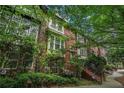 Three-story brick townhome showcases classic architecture and lush, green landscaping at 75 High Top Ln, Atlanta, GA 30328