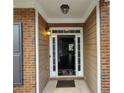 Elegant front door with decorative glass panels and sidelights, set within a charming brick and siding facade at 1117 Balvaird Dr, Lawrenceville, GA 30045