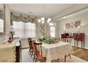 Cozy dining room with a decorative table setting, antique furniture, and a floral curtained window at 186 Greenbrier Way, Canton, GA 30114