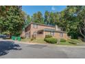 Rear view of brick home on a manicured lawn, surrounded by mature trees, showing a well-maintained community at 115 Plantation Dr, Clarkston, GA 30021