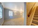 Bright and spacious living room featuring neutral carpeting, staircase and decorative lighting fixtures at 115 Plantation Dr, Clarkston, GA 30021