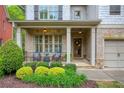 Inviting front porch with stone pathway, brick columns, seating area, and beautiful landscaping at 4674 Lakeway Pl, Alpharetta, GA 30005