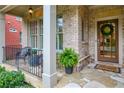 Close-up of a welcoming front porch with a wreath, stone flooring, and comfortable seating at 4674 Lakeway Pl, Alpharetta, GA 30005