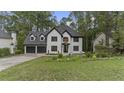 Beautiful two-story home featuring a two-car garage, lush lawn, and mature trees at 4978 Thornwood Nw Cv, Acworth, GA 30102