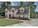 Well-maintained two-story home featuring a lush lawn, mature trees, and a long, paved driveway at 509 Orchards Walk, Stone Mountain, GA 30087