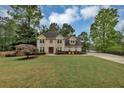Inviting two-story home boasting a manicured front lawn, lush plantings, and a long, paved driveway at 509 Orchards Walk, Stone Mountain, GA 30087