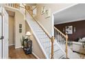 Bright foyer features wooden floors, staircase with white rails, and views to the living room at 230 Bluff Oak Dr, Roswell, GA 30076