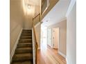 Open staircase with wood railing and hardwood floors adjacent to the hallway at 2656 Gadsen Walk, Duluth, GA 30097